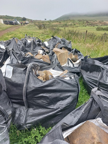 Bags of heavy stone wait to be lifted to the top of Roseberry Topping 