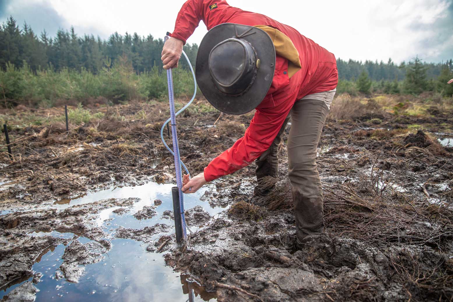 Person carrying out dipwell monitoring as part of a peatland restoration programme. This is used to measure the water table. Credit Charlie Fox.
